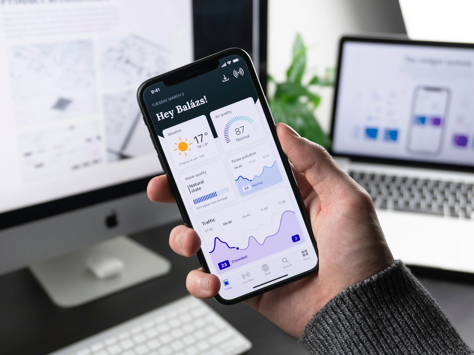 Person holding a smartphone displaying a data dashboard