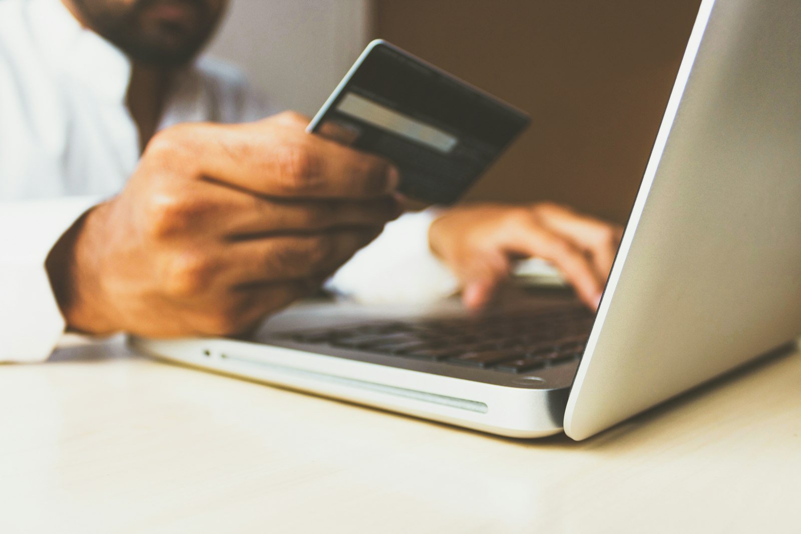 Person shopping online with a laptop and card